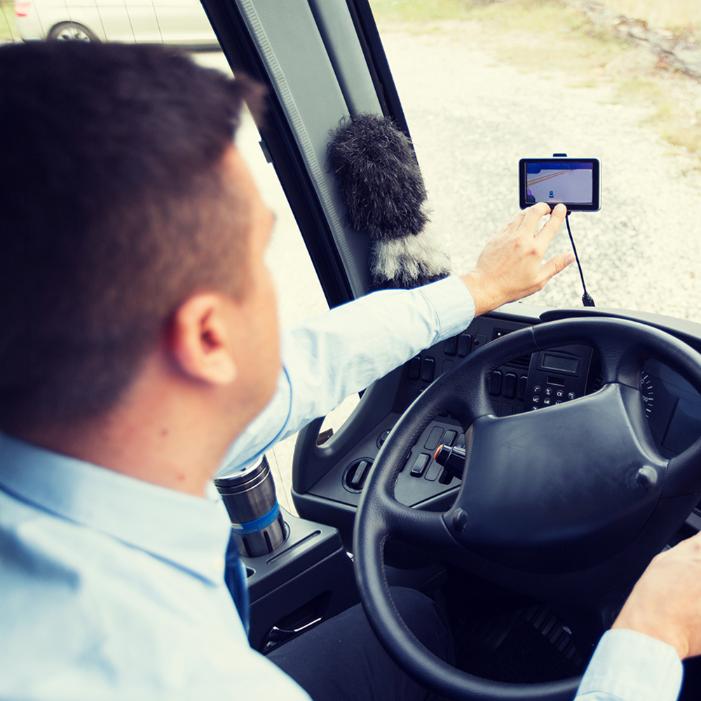 transport, transportation, tourism, navigation and people concept - close up of bus driver with gps navigator driving passenger bus